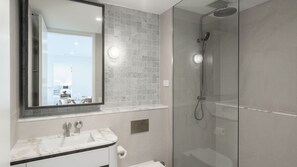 A modern bathroom with a glass-enclosed shower, a marble sink, and a large mirror. - Marina Getaway ~ Captivating 2-bedroom that accommodates up to 4 guests (Shell Cove)