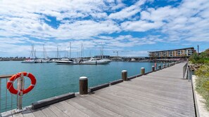 Un muelle de madera que conduce a un puerto deportivo con varios yates amarrados.