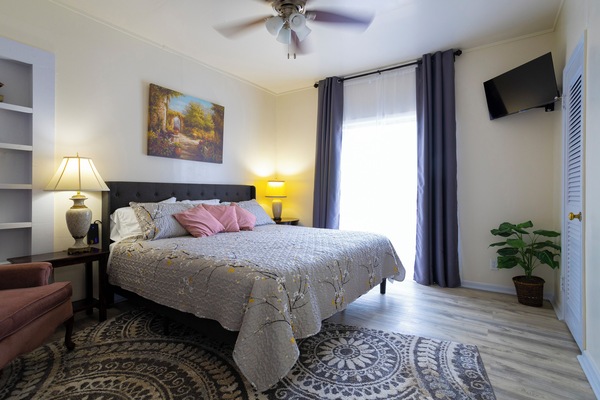 Bathed in natural light, the bedroom retreat, features a plush king bed & smart TV