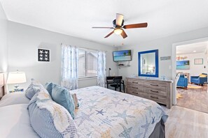 A bedroom with a bed, a desk, a dresser, a ceiling fan, and a TV. - Starfish Shore -2BD/2BA Condo with BEAUTIFUL Ocean Views (Myrtle Beach)