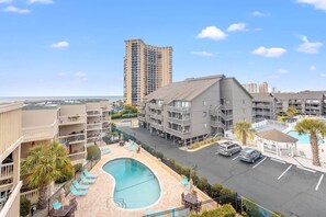 A hotel with a swimming pool, multiple balconies, and a parking area. - Starfish Shore -2BD/2BA Condo with BEAUTIFUL Ocean Views (Myrtle Beach)