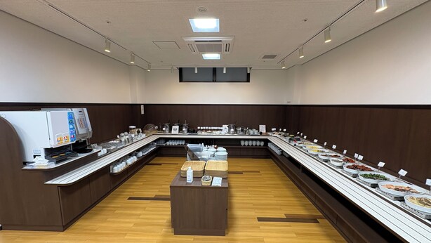 A buffet setup with a coffee machine, multiple serving counters, and a central serving station. - Hotel Alpha-One Iwaki (Iwaki)