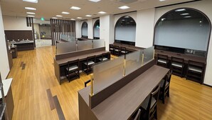A modern restaurant with wooden floors, high tables, and arched windows. - Hotel Alpha-One Iwaki (Iwaki)