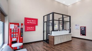 A reception area with a modern design, including a reception desk, a vending machine, and a sign indicating free Wi-Fi in all rooms. - Red Roof Inn PLUS+ Brooklyn - 3rd Ave (Brooklyn)
