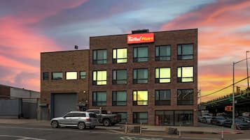 A multi-story building with a Red Roof Plus sign, a brick facade, and multiple windows.