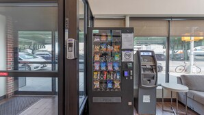 Ein Verkaufsautomat mit Snacks und ein Bargeldautomat in einem Gebäude.