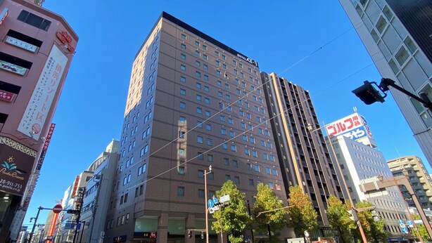 Un hotel de varios pisos con un diseño moderno, con numerosas ventanas y un letrero llamativo.