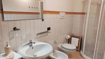 Ein Badezimmer mit Waschbecken, Bidet, Toilette und Dusche.