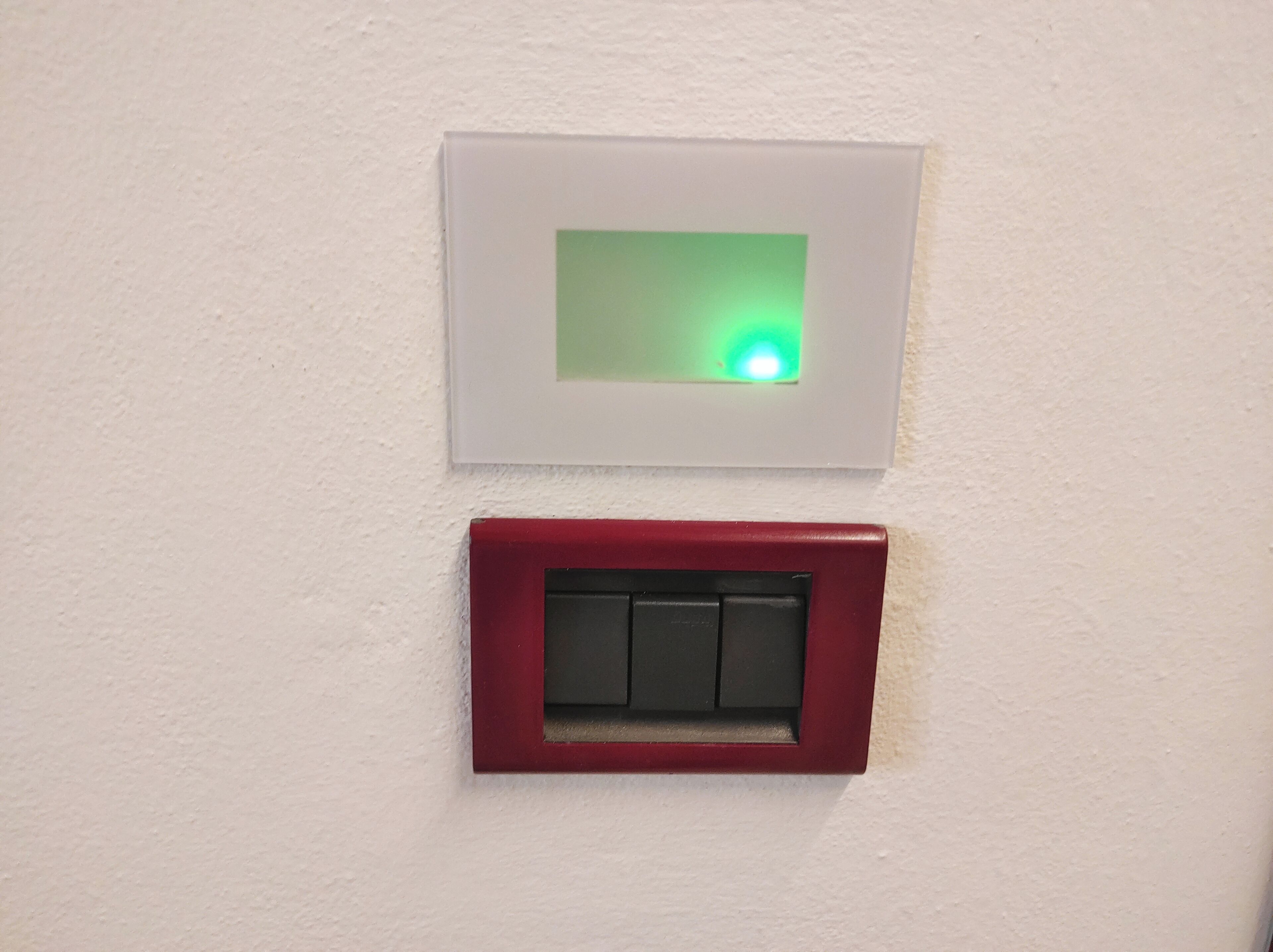 Ein an der Wand montierter Lichtschalter und ein Rauchmelder.