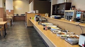 Un buffet con diversos alimentos y salsas sobre una mesa.