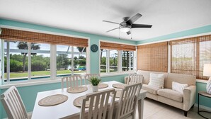 A dining area with a table, chairs, and a ceiling fan. - Waterfront 3BR – Pool, Dock, Kayaks & Beach (Englewood)