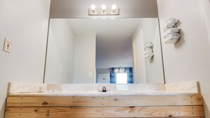 A bathroom with a wooden vanity, a mirror, and a towel rack. - Capital O 3Y Motel Mount Vernon Renfro Valley (Mount Vernon)