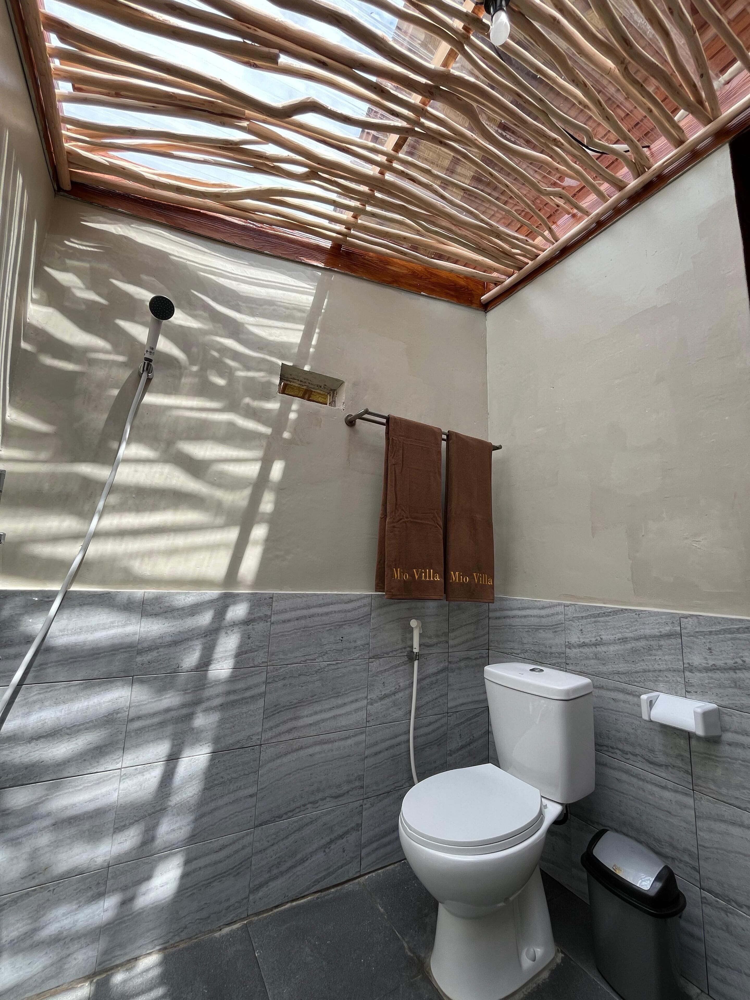 Un baño moderno con ducha, inodoro y toallero.