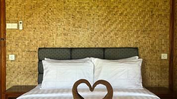 Een bed met een handdoekarrangement in de vorm van een hart en de tekst 'MIO VILLA' op de plaid.