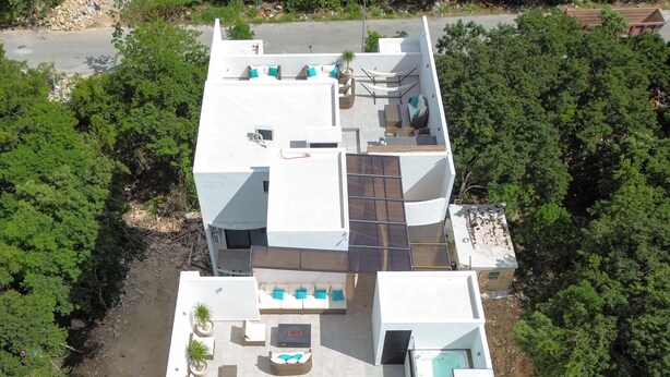 A modern two-story house with a rooftop terrace, a swimming pool, and a patio area. - Modern vacation apartment with gym, jacuzzi, rooftop pool and sauna. (Playa del Carmen)