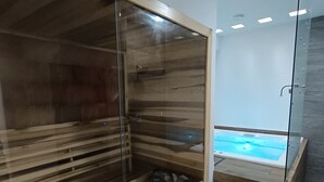 A modern bathroom with a glass-enclosed shower, wooden flooring, and a built-in jacuzzi. - Modern vacation apartment with gym, jacuzzi, rooftop pool and sauna. (Playa del Carmen)