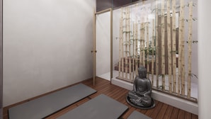 A room with wooden flooring, a meditation area with mats, a statue, and a bamboo screen. - Modern vacation apartment with gym, jacuzzi, rooftop pool and sauna. (Playa del Carmen)