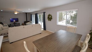Una sala de estar con sofá, una mesa de comedor y televisor.