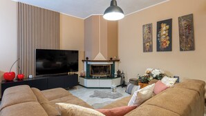 A living room with a fireplace, a television, and a sofa.