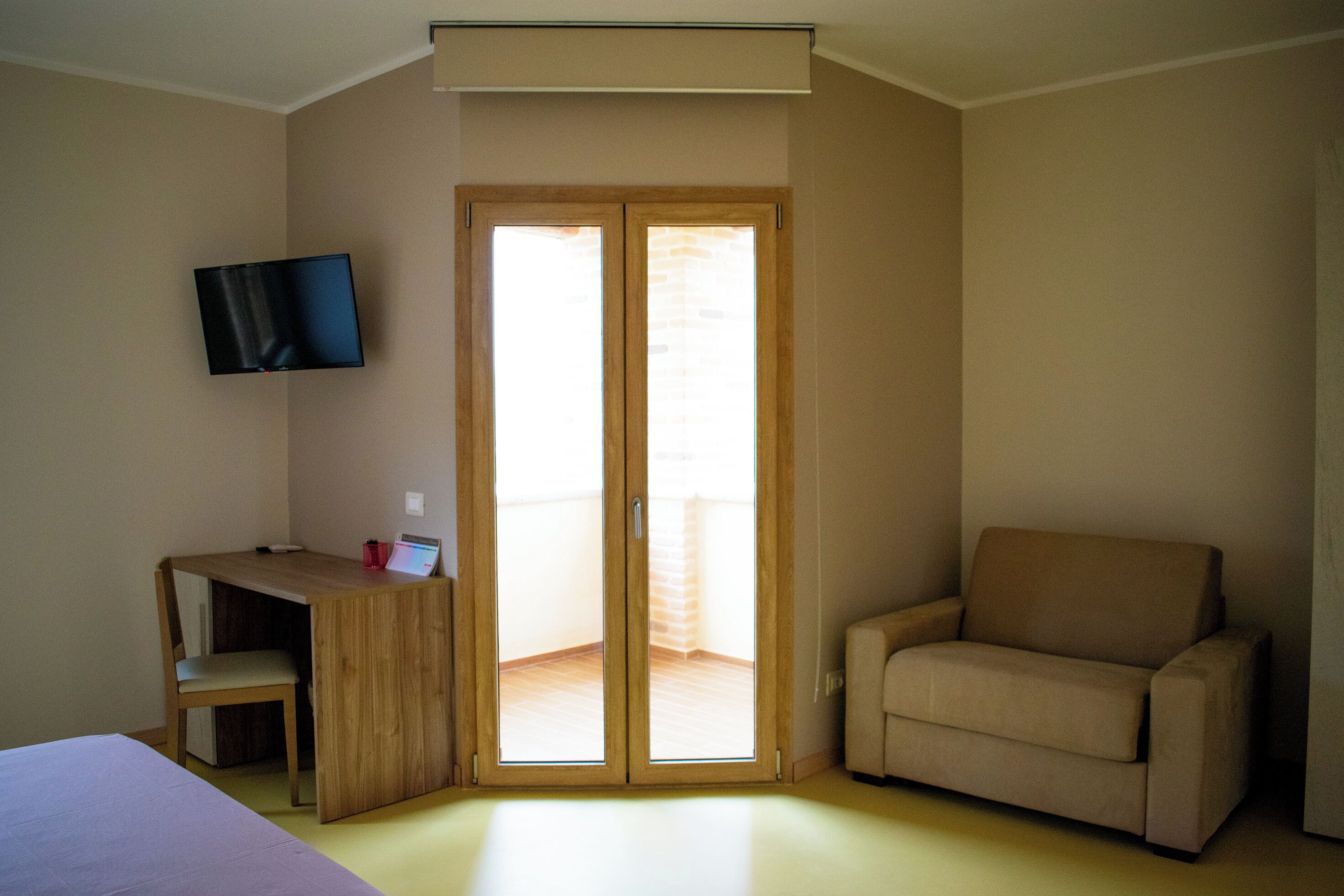 A room with a desk, chair, and a sofa.