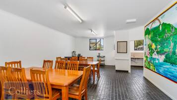 A conference room with a long table and chairs, a window with a view, and a large painting on the wall.