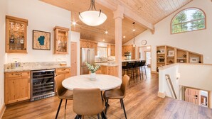 A spacious kitchen with wooden cabinets, a central island, and a dining area with chairs.