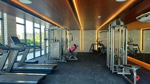 A gym with treadmills, weight machines, and a person exercising. - Porto Alto Resort - GAV Resorts (NEAR PORTO DE GALINHA BEACH).  (Ipojuca)