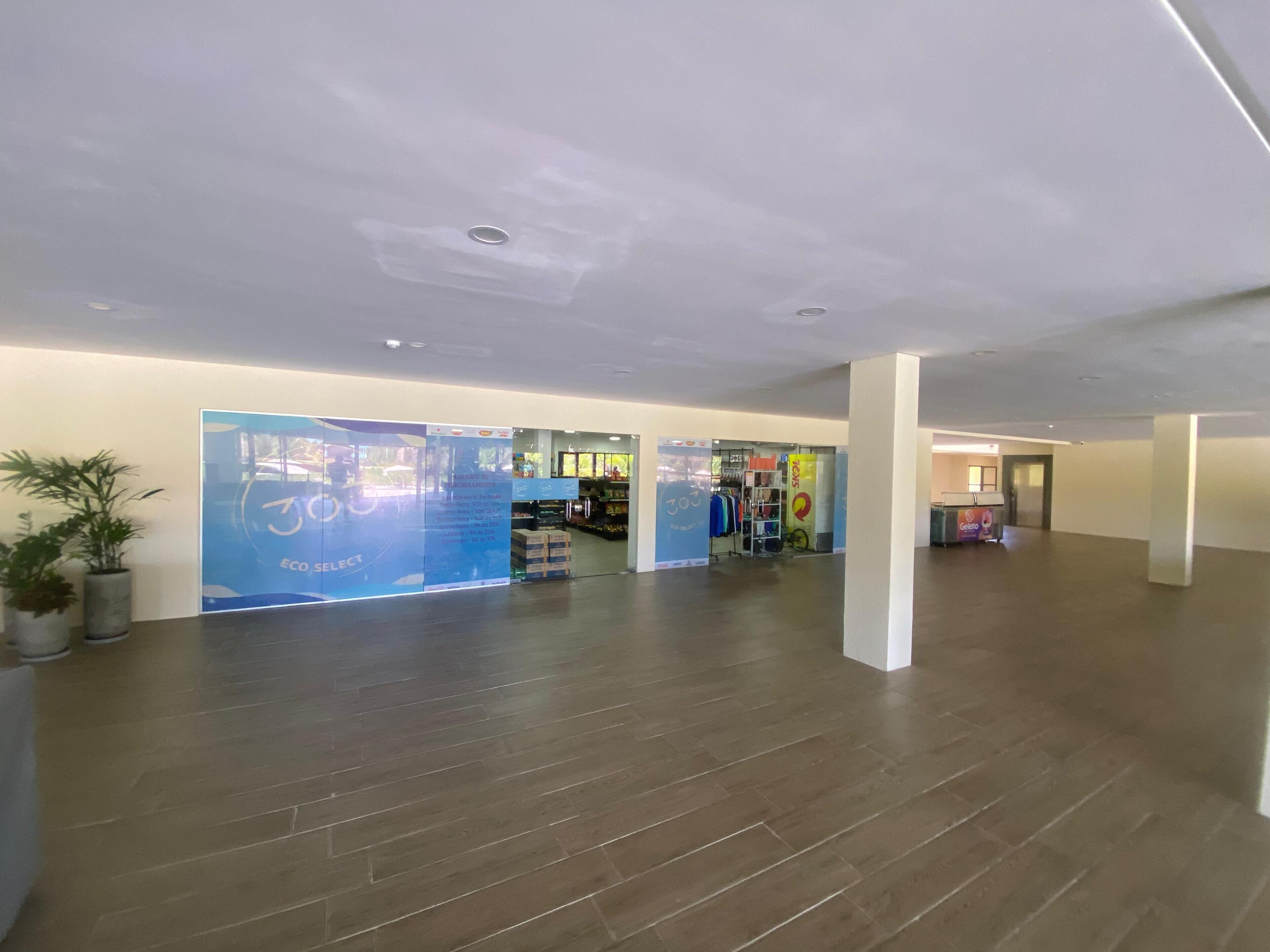 A spacious lobby with a wooden floor, a reception desk, and a large blue advertisement.