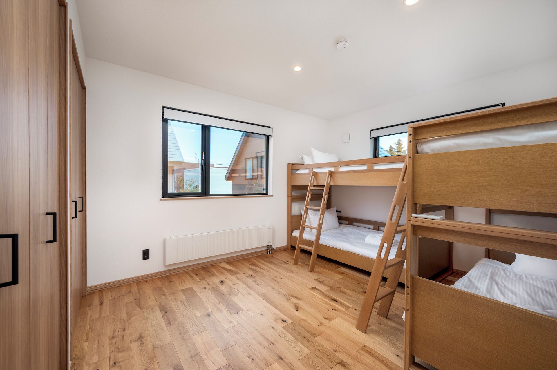 A room with bunk beds, a window, and a radiator.