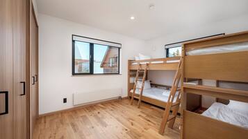 A room with bunk beds, a window, and a radiator.
