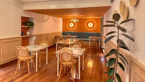 Interior de restaurante con mobiliario de madera, zona central de mesas y detalles decorativos en las paredes.