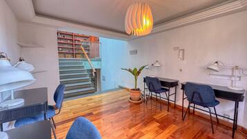 Ein modernes Wohnzimmer mit Treppe, Holzboden und einem Essbereich mit Stühlen und Tischen.