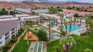 Et hotel med flere bygninger, en swimmingpool og en legeplads.