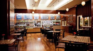 Enjoy dining in this traditional restaurant with a counter, tables, and a display case.