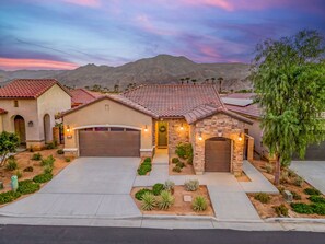 A residential property with a garage, a driveway, and a landscaped front yard.
