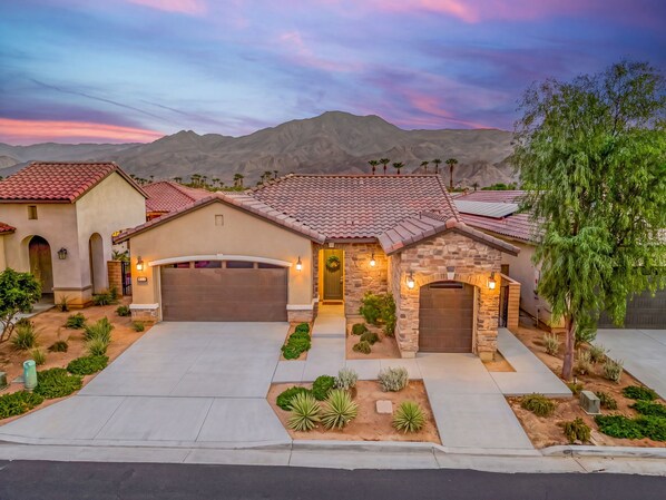 A residential property with a garage, a driveway, and a landscaped front yard.
