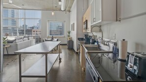 Eine moderne Küche mit einer großen Kochinsel, integrierten Geräten und Blick auf die Stadt.