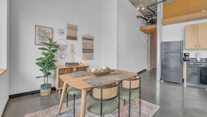 A modern kitchen with a refrigerator, stove, and wooden cabinets. - Downtown 1 Bedroom Loft in the Gulch (Nashville)