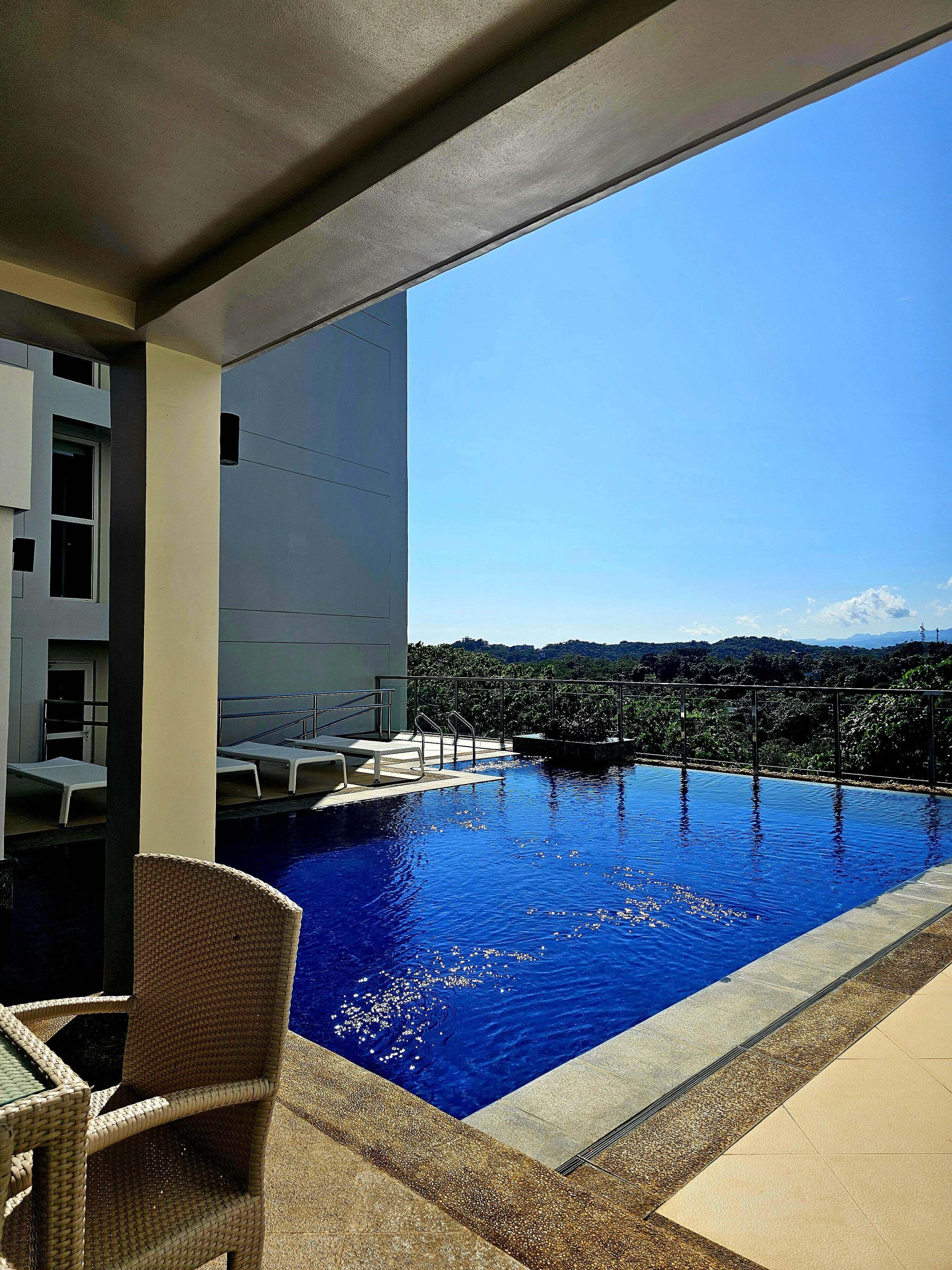 Een buitenzwembad, een verwarmd zwembad, ligstoelen bij het zwembad