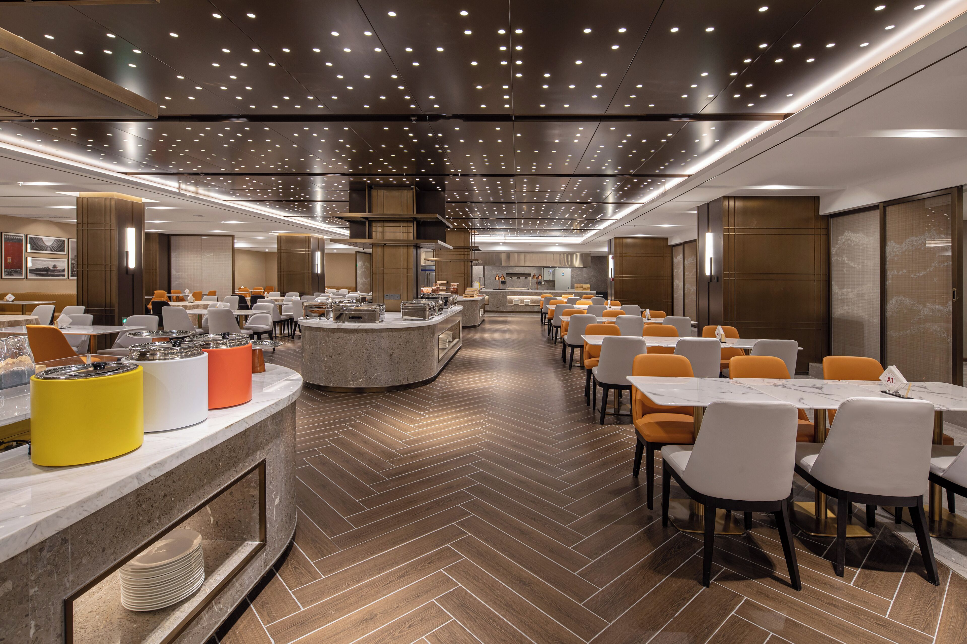 A modern dining area with a central counter, multiple tables, and chairs.