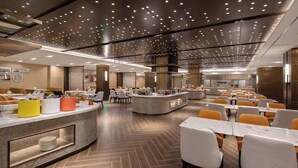 Un comedor moderno con una barra central, varias mesas y sillas.
