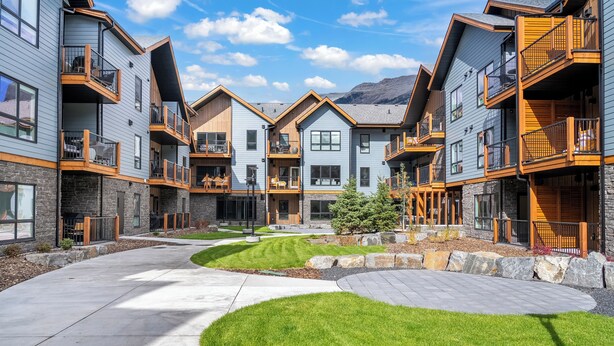 A modern multi-story building with balconies, a central courtyard, and a stone facade. - All Year Heated Pool & Tub! New! (Bighorn No. 8)