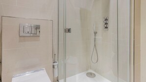 A modern bathroom with a glass-enclosed shower, a toilet, and a sink. - Blueground | Bloomsbury 1bd apartment (London)