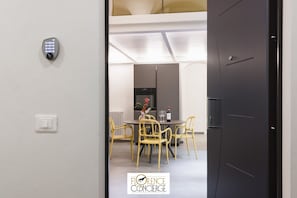 Ein modernes Interieur mit Essbereich, gelben Stühlen und einem Tisch mit einer Vase und einer Weinflasche.