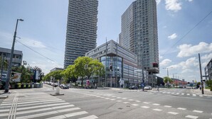 A modern urban intersection with tall buildings, crosswalks, and traffic lights. - Blueground | Landstraße, pool, gym, sauna & a/c (Vienna)