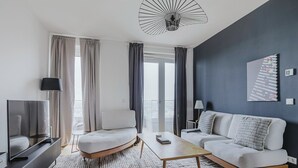 A modern living room with a sofa, a coffee table, and a TV. - Blueground | Landstraße, pool, gym, sauna & a/c (Vienna)