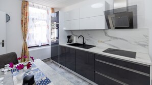 Eine moderne Küche mit einem schwarzen Spülbecken, weißen Schränken und einer eingebauten Dunstabzugshaube.