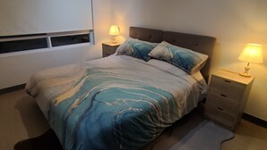 A bedroom with a bed, two bedside tables with lamps, a window, and a carpet. - Beautiful and comfortable department (Ñuñoa)