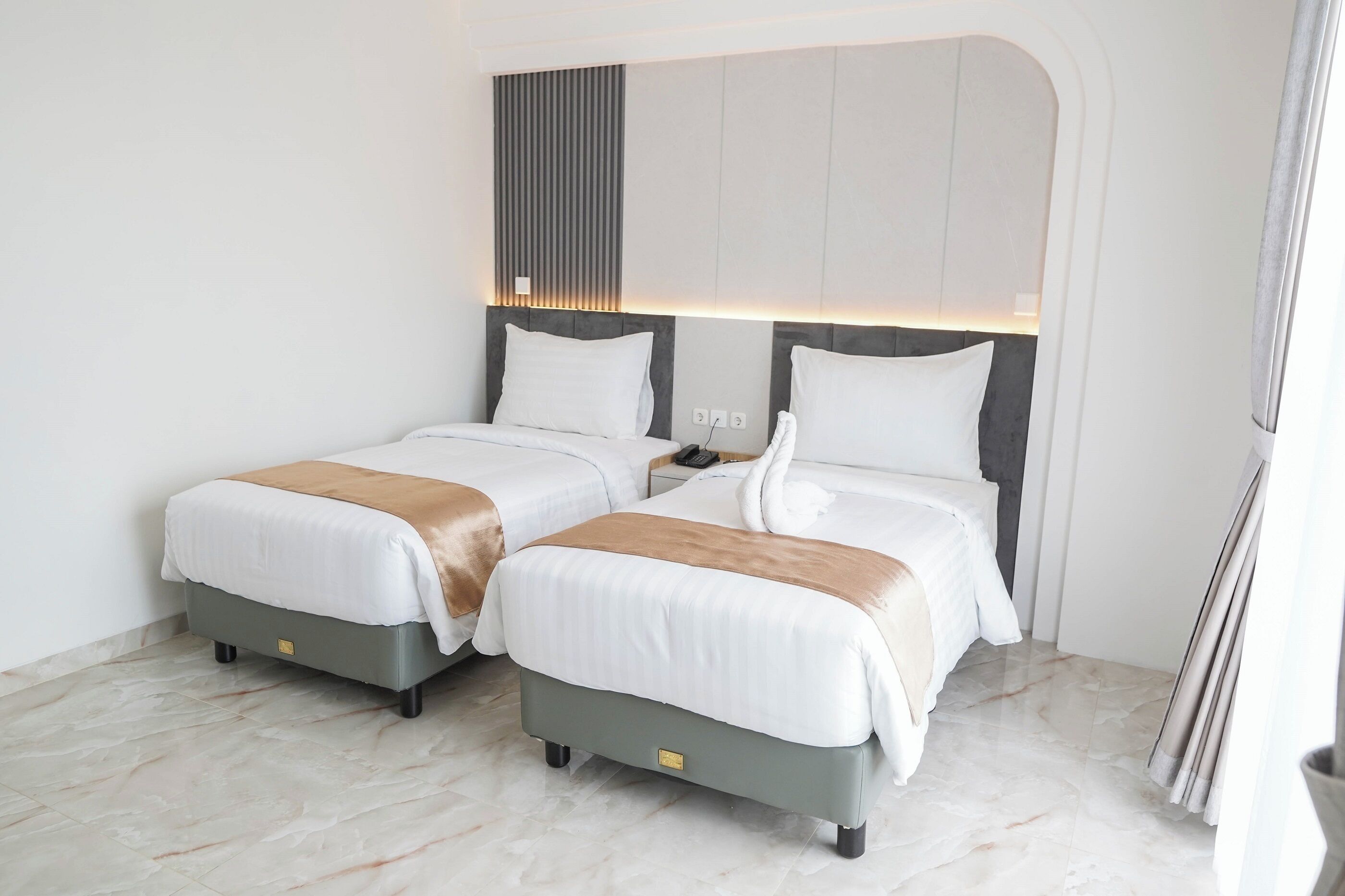 A hotel room with two beds, a modern headboard, and a marble floor.