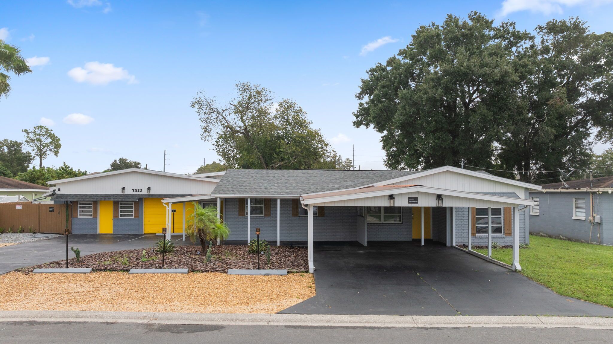 Un motel composé d’un bâtiment d’un seul étage, d’un espace de stationnement couvert et d’un petit jardin aménagé à l’avant.